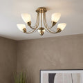 Altair antique brass semi-flush ceiling light with five upward-facing frosted glass shades in a neutral room.