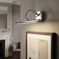 Polished chrome LED picture light mounted on a wall above a framed artwork in a living room.