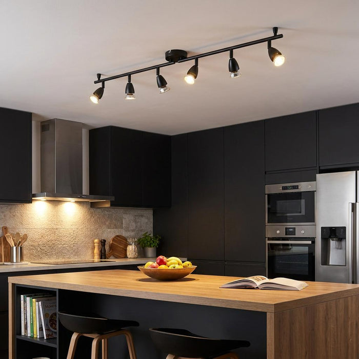 Amalfi 6-light black adjustable spotlight bar mounted on a kitchen ceiling over a wooden island.