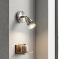 Amalfi adjustable satin nickel spotlight on a gray wall illuminating a small wooden shelf and vase.