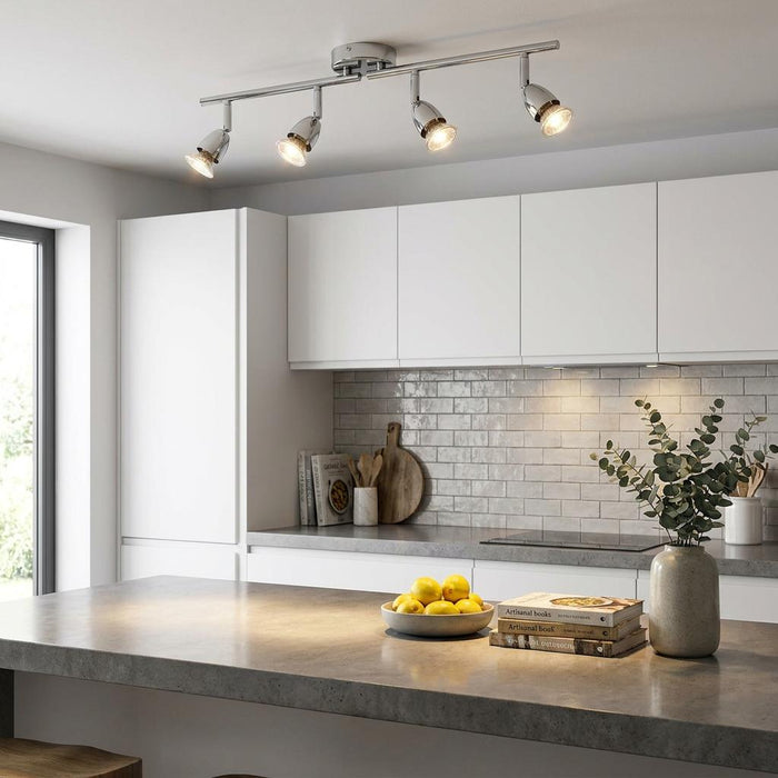 Saxby Amalfi chrome 4-light ceiling spotlight bar illuminating a modern white and grey kitchen interior.