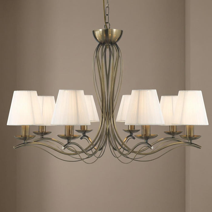 8-light antique brass chandelier with elegant sweeping wire arms and cream pleated fabric shades.