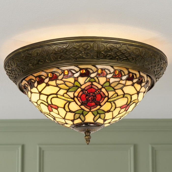 Ornate Tiffany-style flush ceiling light with red rose stained glass and intricate bronze patterned rim.
