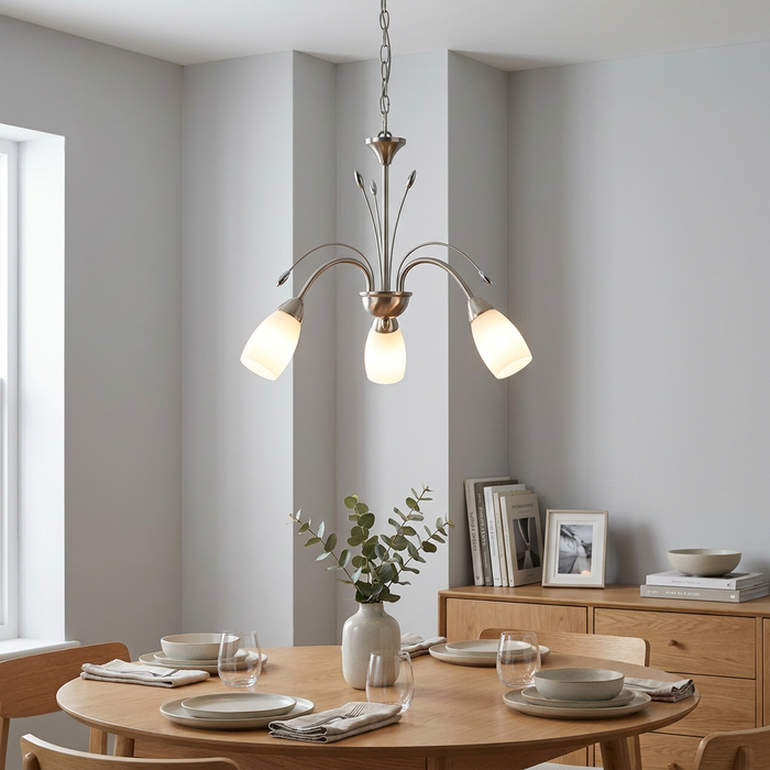 Antique chrome three-light chandelier with frosted glass shades hanging over a wooden dining table in a neutral room.