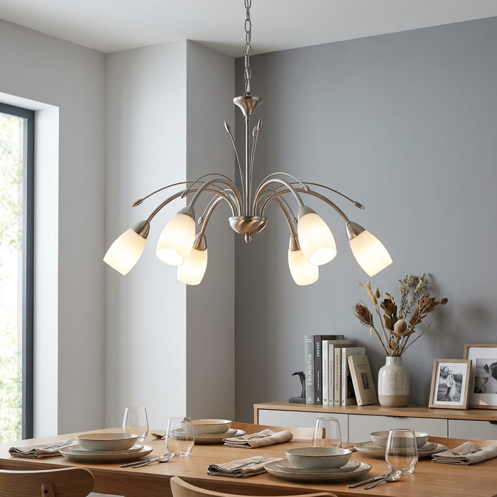 Six-light antique chrome chandelier with arched arms and white glass shades hanging above a set dining table.