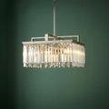 Aries 4-light nickel chandelier with rectangular crystal prisms hanging against a dark green wall.