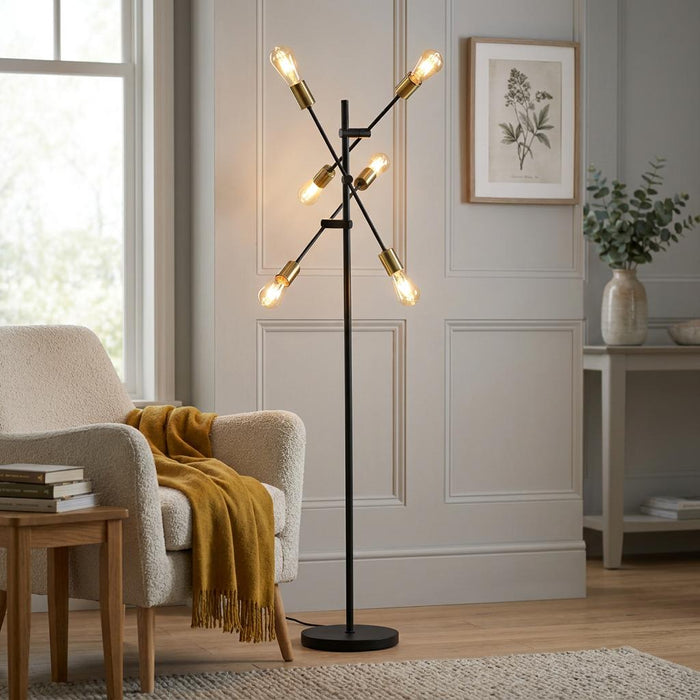 Armstrong Black & Satin Brass Modern Floor Lamp with glowing Edison bulbs in a cozy living room.