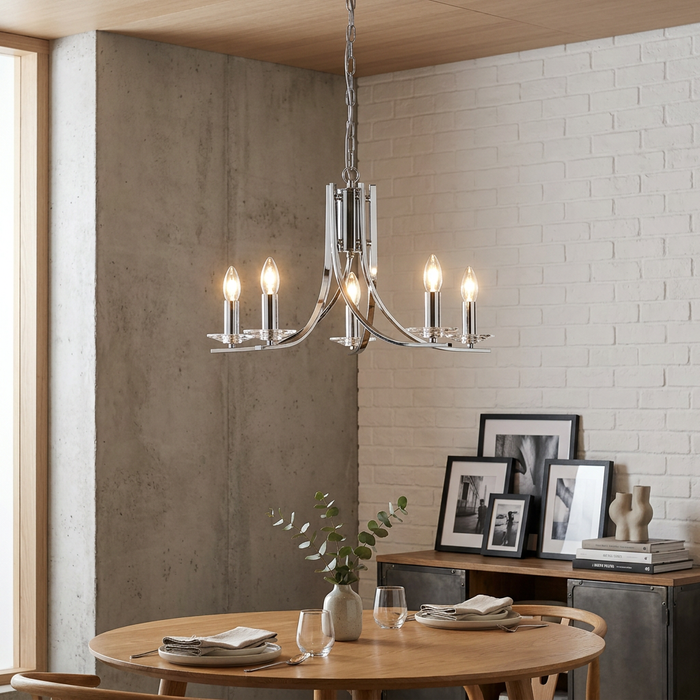 A five-light chrome chandelier with glass sconces hangs above a wooden dining table in a modern room.