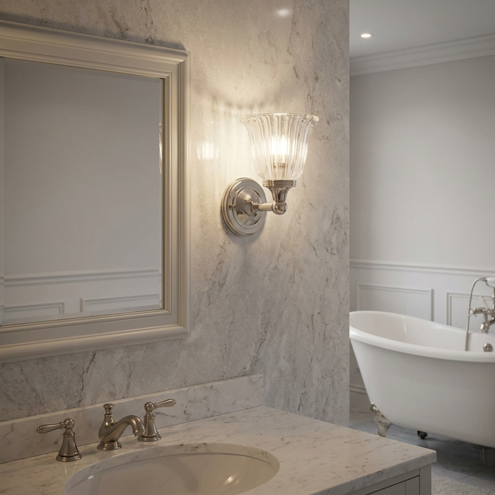 Austen cloche shade polished nickel bathroom wall light mounted on a marble wall beside a mirror.
