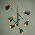 Bali 6-light ceiling light with adjustable black and gold conical shades against a sage green background.