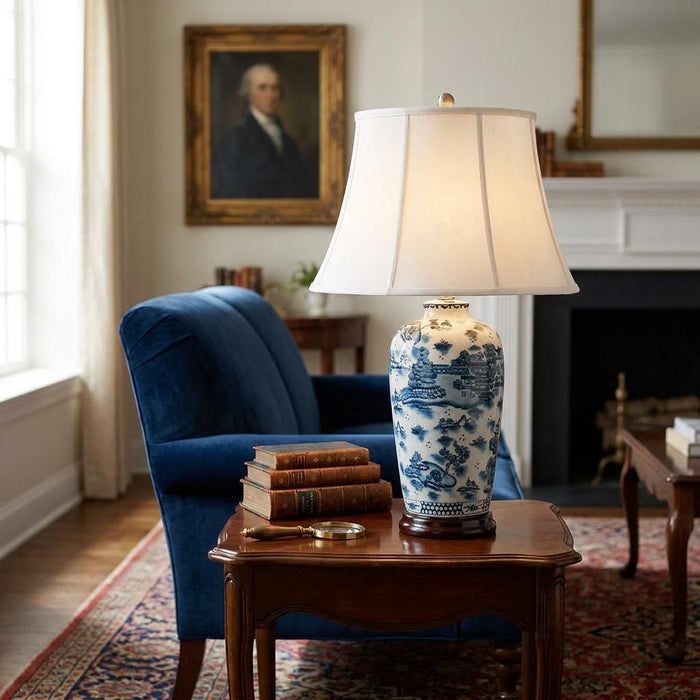 Blue and white ceramic table lamp with a landscape pattern on a wooden side table in a classic living room.