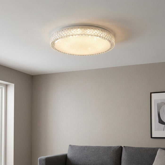 Sparkly round flush ceiling light with a crystal-effect rim glowing warmly in a modern living room.