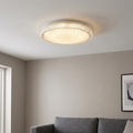 Sparkly round flush ceiling light with a crystal-effect rim glowing warmly in a modern living room.