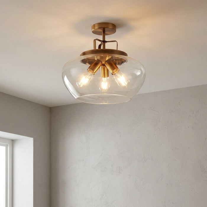 A bronze 3-light semi-flush ceiling light with a clear glass shade illuminating a neutral interior space.