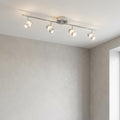 Modern chrome adjustable four-light spotlight bar with bubble glass details mounted on a plain ceiling.
