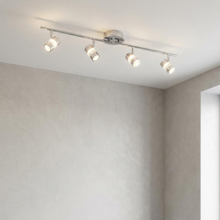 Modern chrome adjustable four-light spotlight bar with bubble glass details mounted on a plain ceiling.