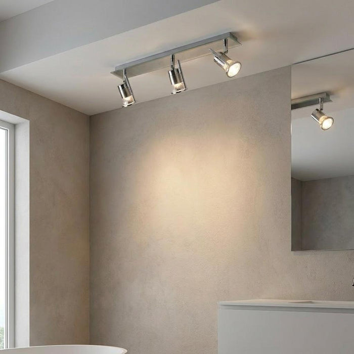 A Cara chrome finish 3 light bathroom ceiling spotlight bar mounted on a beige ceiling in a modern bathroom.
