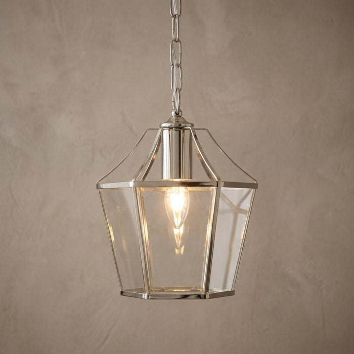Dulverton antique chrome ceiling lantern with clear glass panels hanging from a chain against a neutral wall.