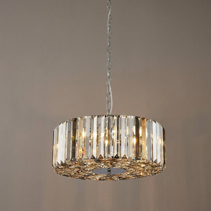 A cylindrical chrome pendant light with smoke and clear glass crystals hanging against a neutral background.