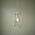 A satin silver geometric cage pendant light with an exposed glowing bulb against a green textured wall.