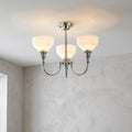 Cheadle chrome 3-light semi-flush ceiling fixture with opal glass shades mounted against a white ceiling.