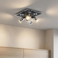 Chrome four-light square flush spotlight fixture illuminated on a ceiling above a wooden cabinet.