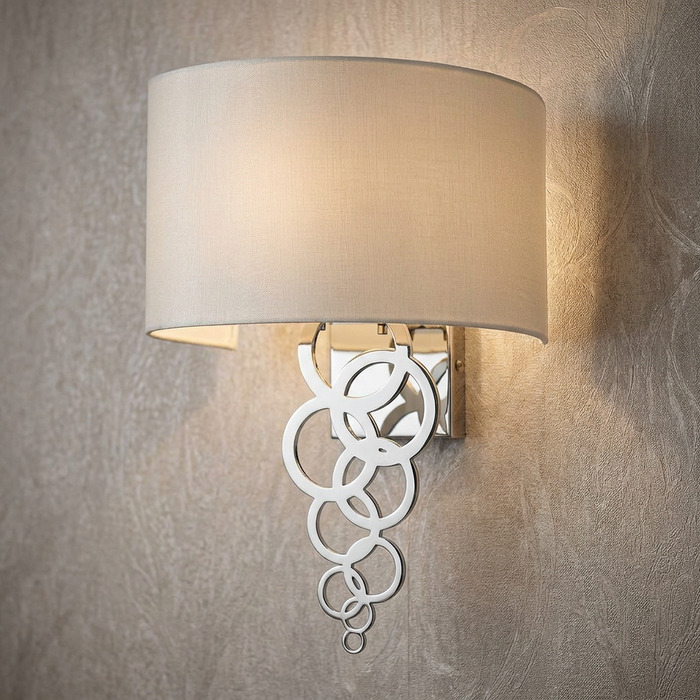Polished chrome wall light with an ivory fabric shade and a decorative cascading bubble ring design.