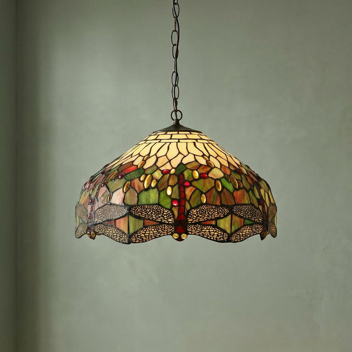 Dragonfly Tiffany pendant light with intricate stained glass dragonfly motifs hanging against a pale green wall.