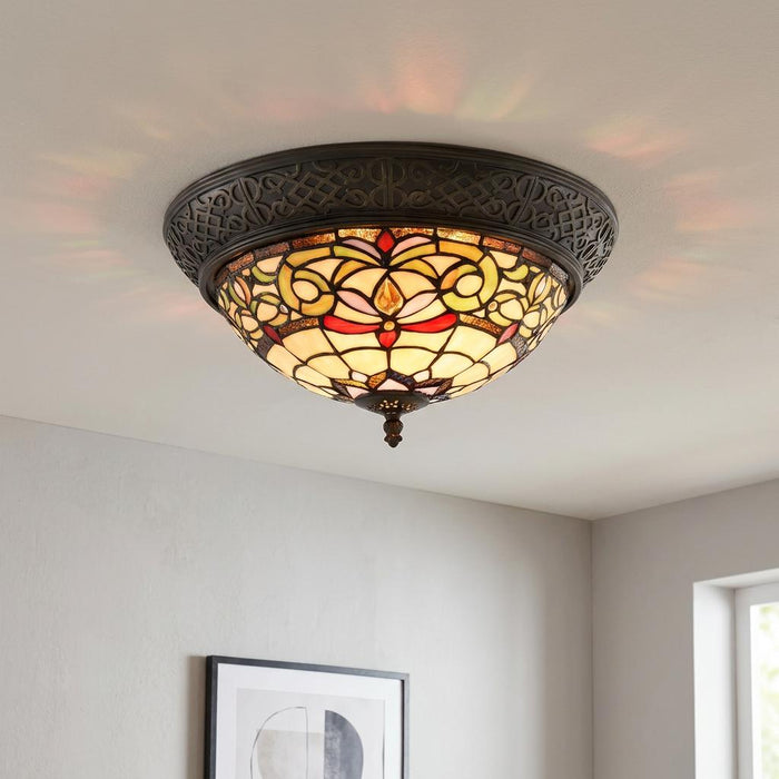 A flush-mounted Tiffany ceiling light with colorful stained glass and a decorative bronze base.