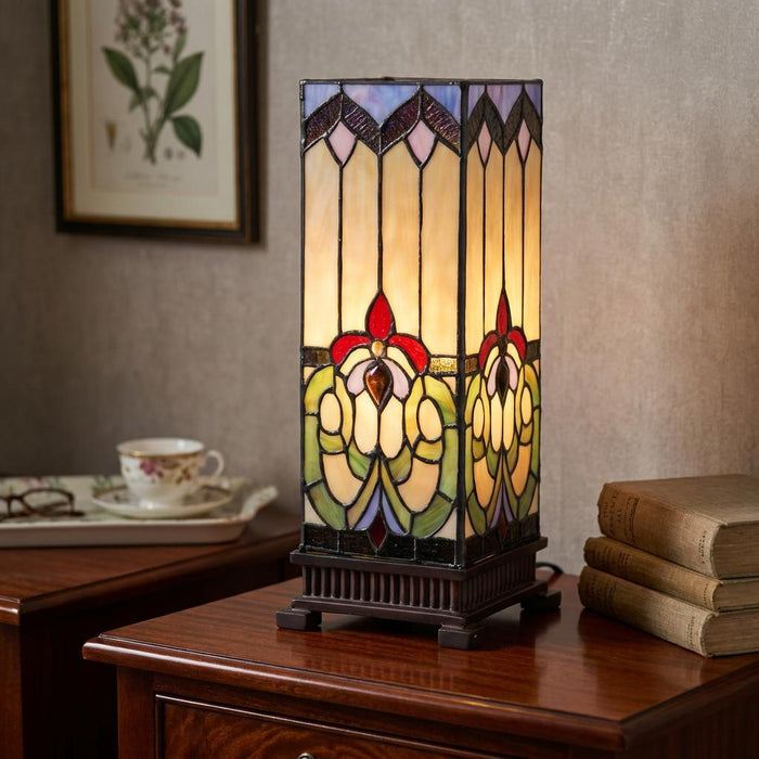 Rectangular Tiffany table lamp with floral stained glass patterns on a wooden bedside table.