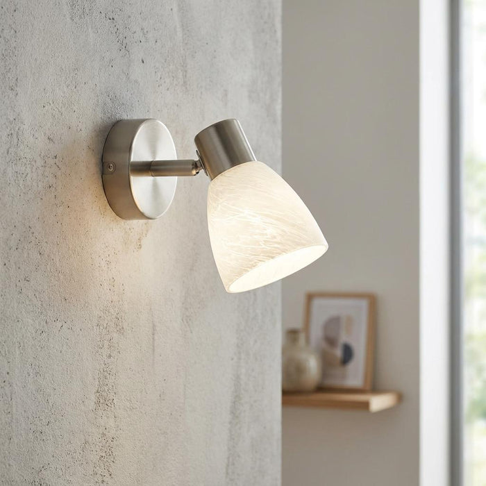 Eglo Dakar 1 wall spotlight with brushed nickel finish and white marbled glass shade on a textured wall.