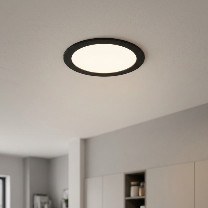 Circular black recessed smart LED ceiling light illuminating a modern kitchen space.