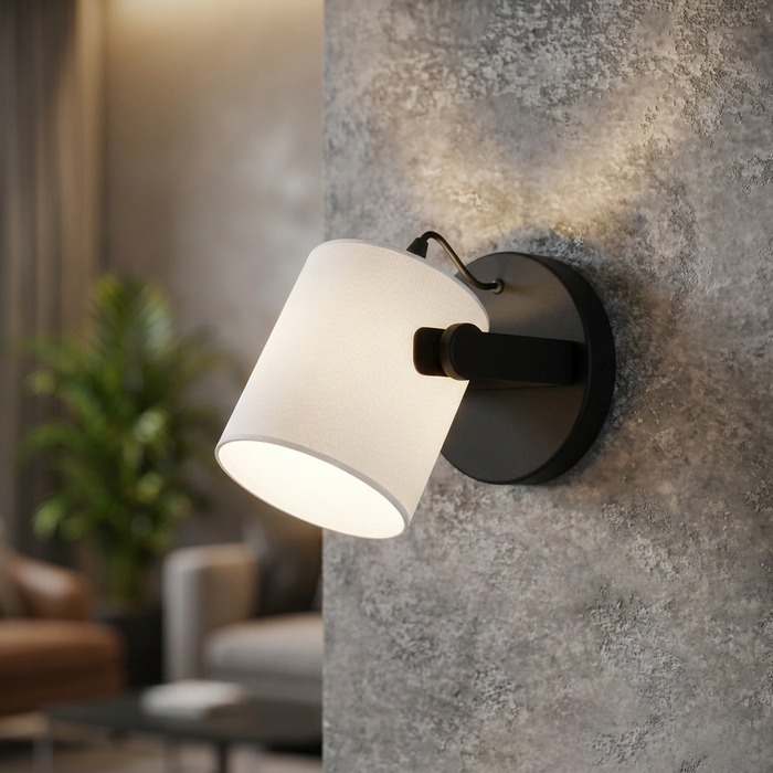Modern black wall light with a white fabric drum shade mounted on a textured grey concrete wall.