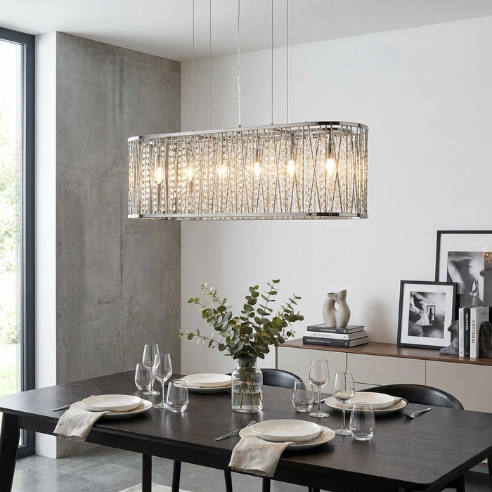 Rectangular Elise chrome and crystal pendant light hanging above a set dining table in a modern room.