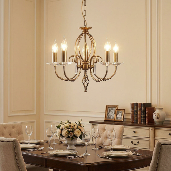 Elstead Aegean aged brass 5-light chandelier illuminated over a formal dining table in a traditional room.