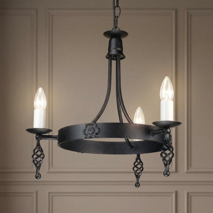 Elstead Belfry three-light black chandelier with lit candle bulbs and wrought iron decorative details.