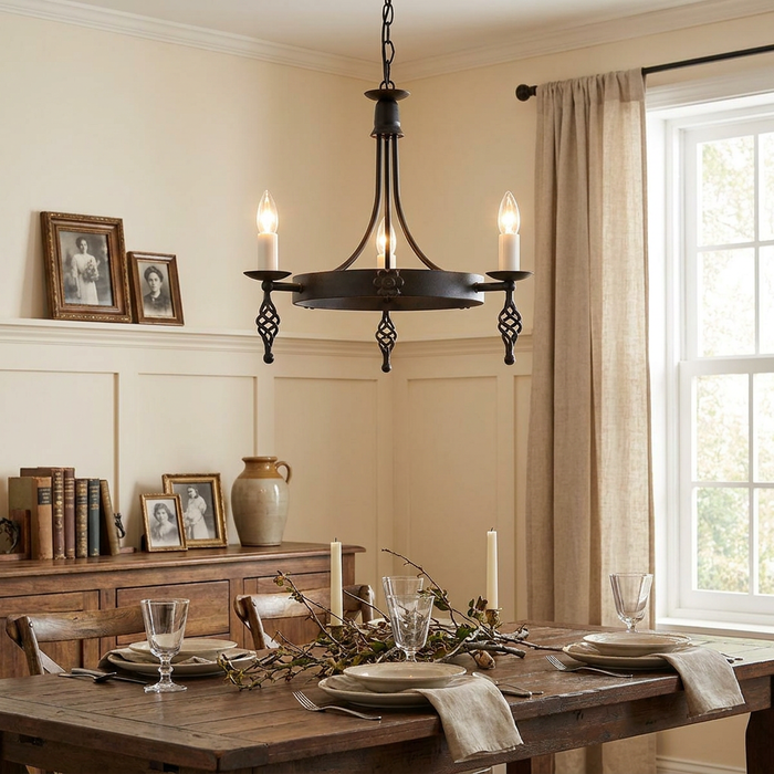 Black 3-light chandelier with candle bulbs hanging above a rustic wooden dining table in a warm room.