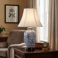 Elstead blue and white ceramic ginger jar table lamp with white shade on a wooden side table in a cozy room.