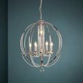 Polished nickel orb chandelier with crystal bead drapes and candle-style bulbs against a teal wall.