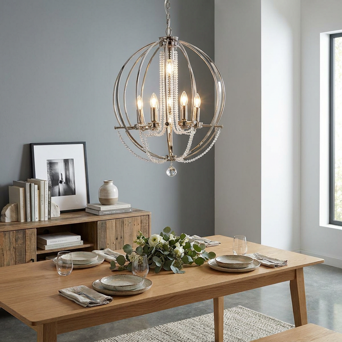 Polished nickel 7-light orb chandelier with crystal beads hanging over a wooden dining table in a modern room.
