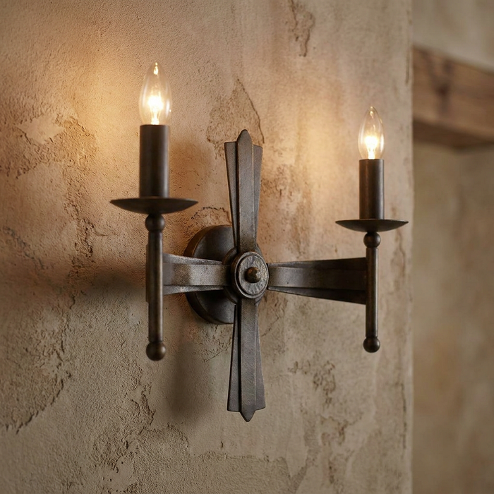 Elstead Cromwell 2 Light Bronze Wall Light with candle bulbs on a rustic textured wall.