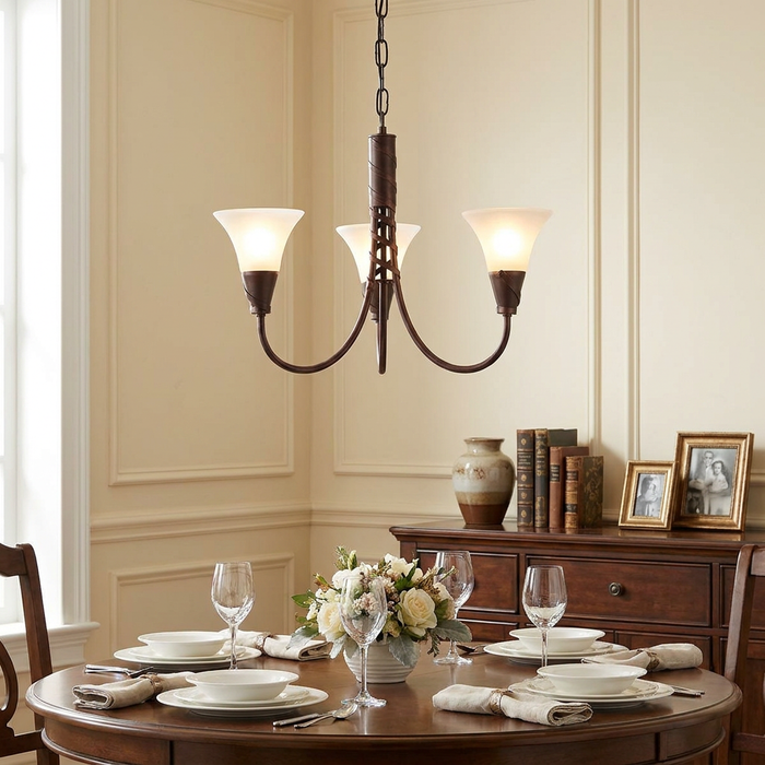 A copper three-light chandelier with frosted glass shades hanging over a dining table set for a meal.