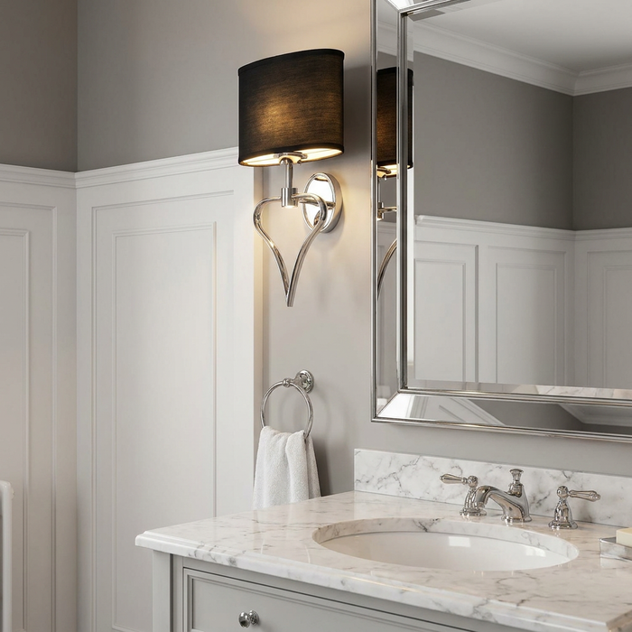 Polished chrome wall light with a black shade and heart-shaped base in a grey and white bathroom.