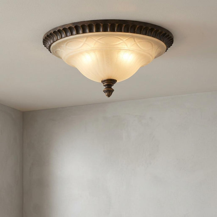 Traditional bronze flush ceiling light with an etched frosted glass bowl shade mounted on a white ceiling.