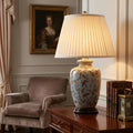 Elstead ceramic table lamp with bird and berry patterns and a pleated shade on a wooden table in a classic room.