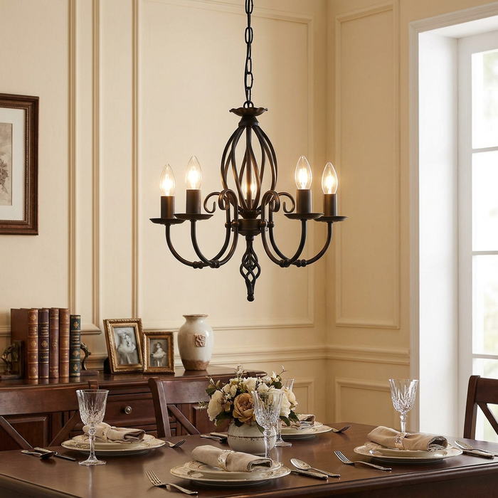 Five-light black wrought iron chandelier hanging over a set dining table in a classic interior.