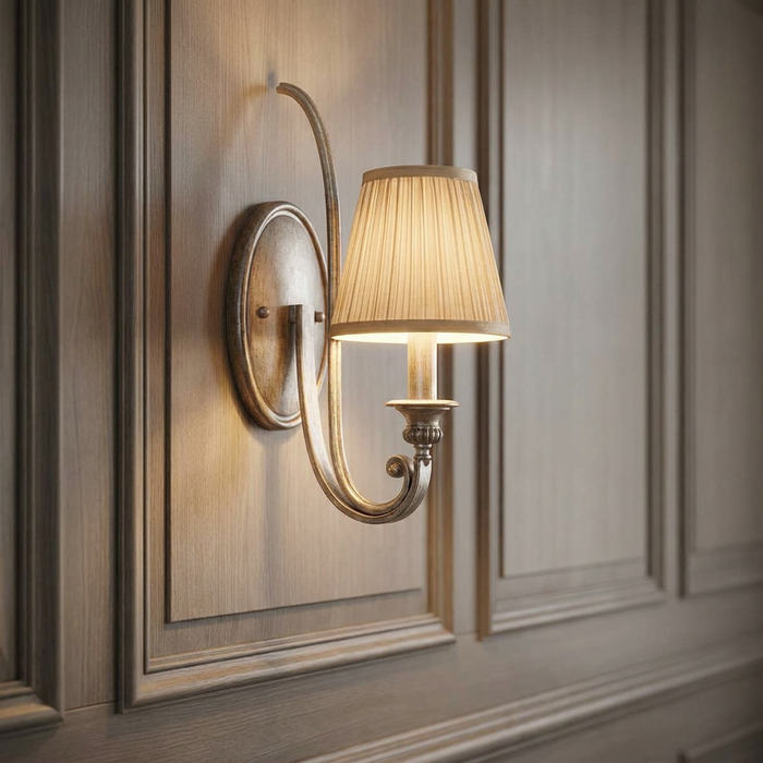 Elegant wall sconce with a curved silver arm and pleated cream shade on a wood-paneled wall.