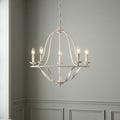 A five-light distressed white chandelier with an open curved cage design hanging in a room with grey wainscoted walls.