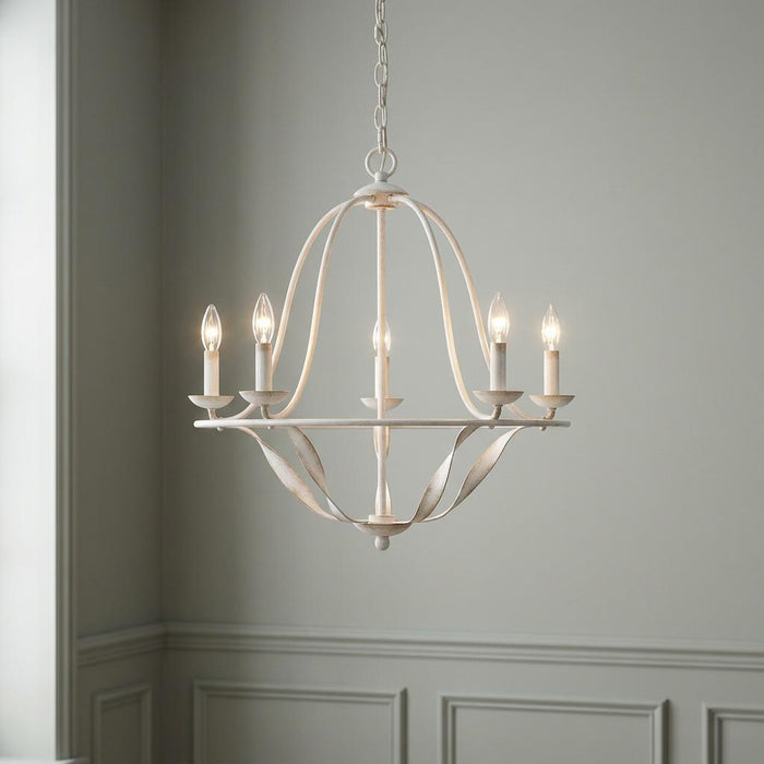 A five-light distressed white chandelier with an open curved cage design hanging in a room with grey wainscoted walls.