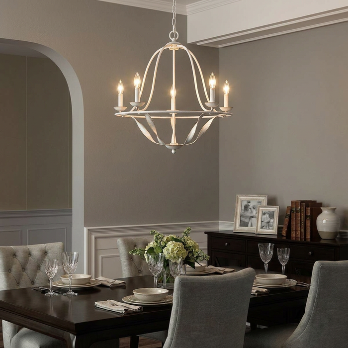 A white Elstead Lighting Quoizel Bradbury 5-light chandelier hanging over an elegantly set dining table.